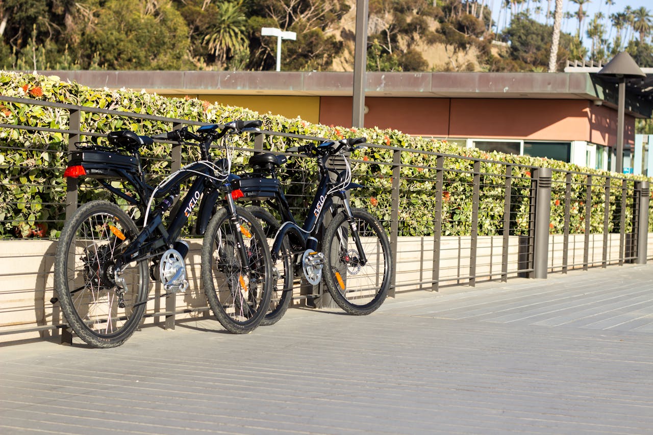 Two electric bikes parked on a sunlit boardwalk in Santa Barbara, California.