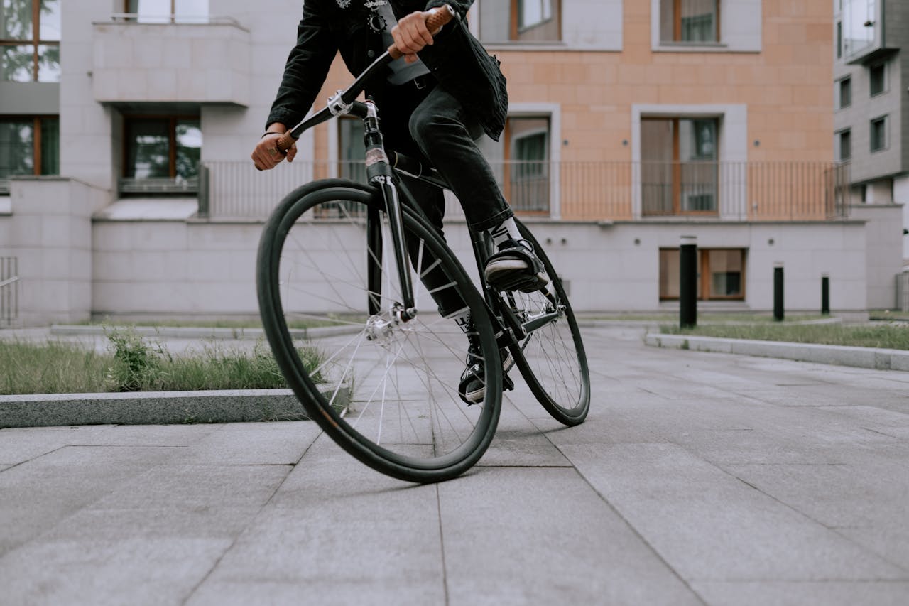 A fashionable cyclist performing a sharp turn on a city street, showcasing agility and style.
